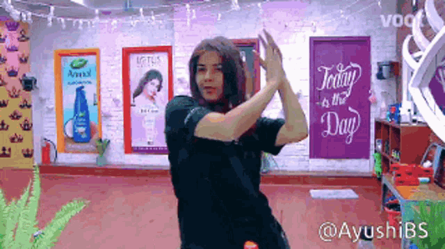 a woman is dancing in front of a sign that says " today is the day "