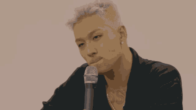 a man with a tattoo that says ss on his chest is sitting in front of a microphone