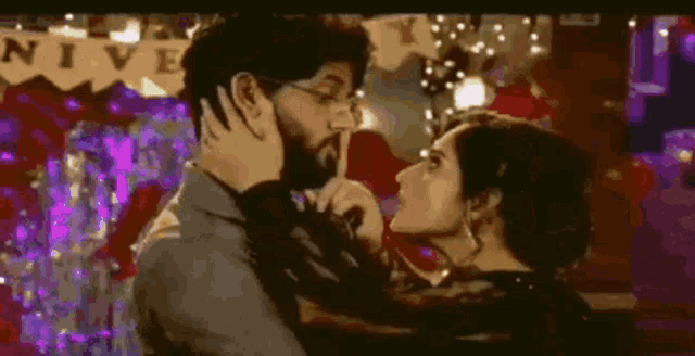 a man and a woman are kissing in front of a banner that says nive
