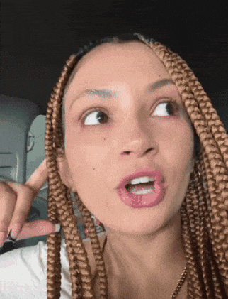 a woman with braided hair making a funny face