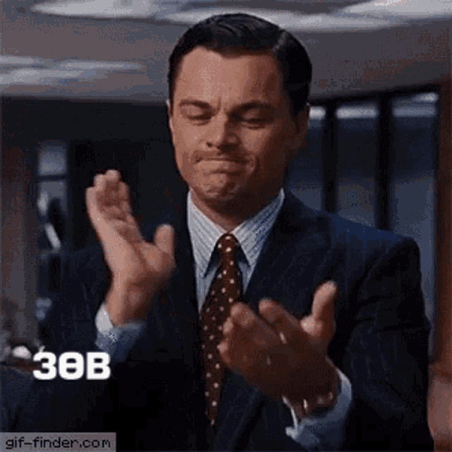 a man in a suit and tie is applauding .