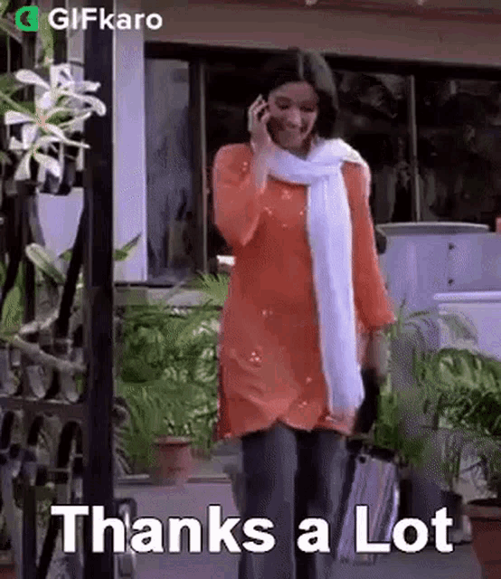 a woman is talking on a cell phone while holding a suitcase and a bag .
