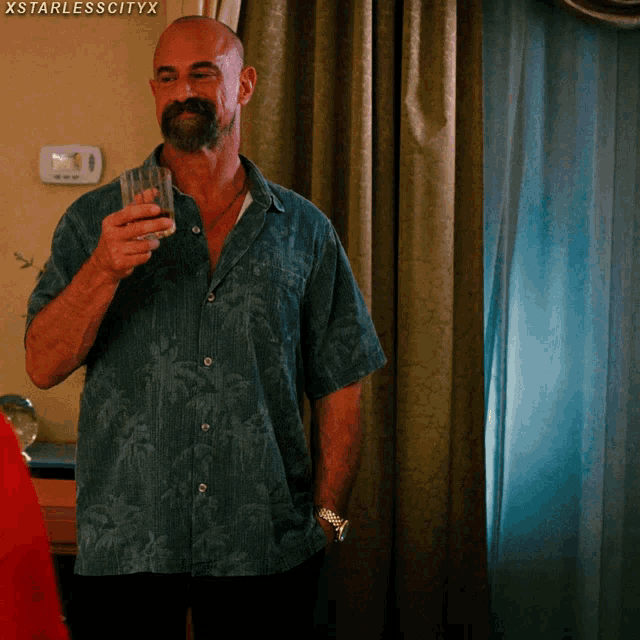 a man with a beard and mustache is holding a glass of whiskey