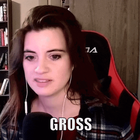 a woman wearing headphones and a plaid shirt says gross in front of a red chair