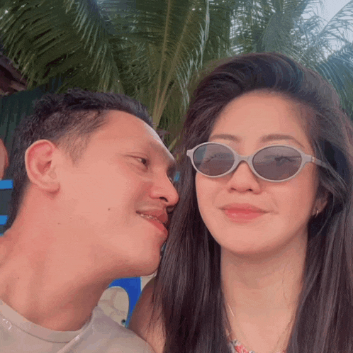 a man and woman wearing sunglasses are kissing