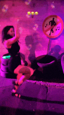 a woman dancing in front of a sign that says no music