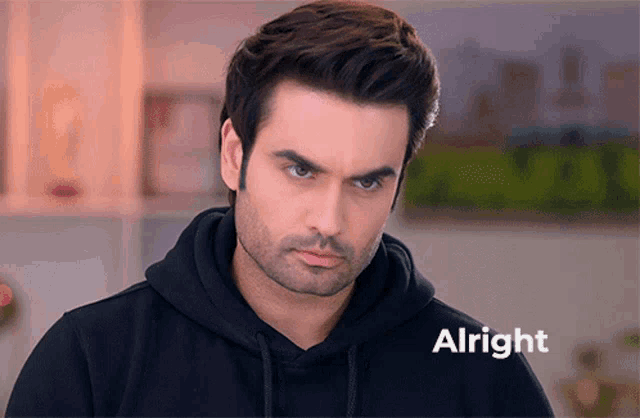 a man wearing a black hoodie with the word alright written on the bottom
