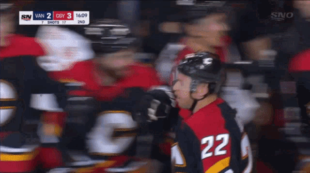 a hockey player with the number 22 on his jersey stands in front of his teammates