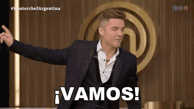 a man in a suit says vamos in front of a master chef logo