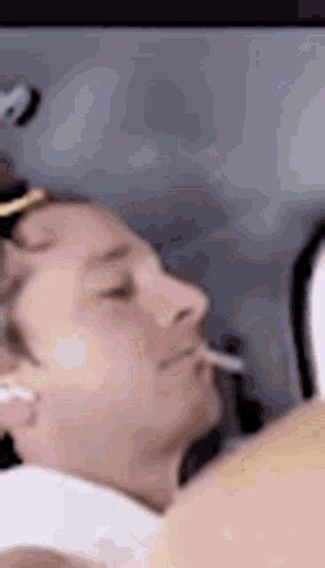 a man is smoking a cigarette while wearing headphones in a car .