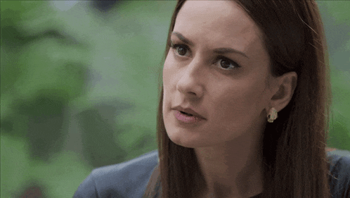 a close up of a woman 's face wearing earrings