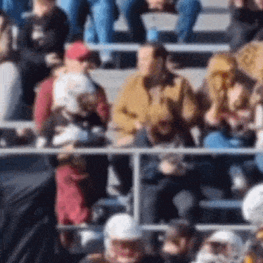 a blurry picture of people sitting in a stadium watching a game
