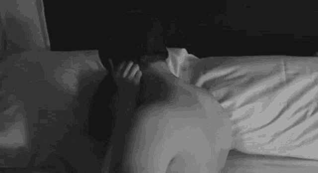 a man and a woman are having sex on a bed .