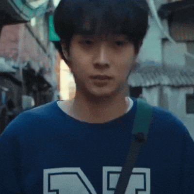 a man in a blue shirt is walking down a street