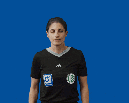 a woman wearing an adidas shirt is clapping her hands in front of a blue background