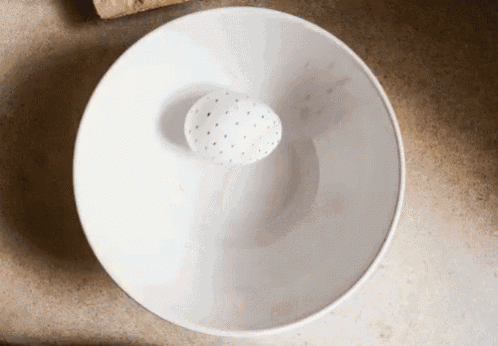 a white bowl with a hole in the middle of it