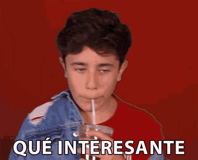 a young boy drinking through a straw with the words que interesante written below him .