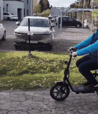 a man is riding a scooter with a license plate that says e7zcl