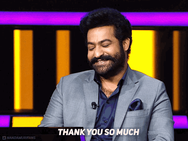 a man in a suit says thank you so much in front of a yellow and purple background