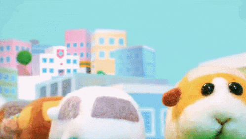 two stuffed animals are standing next to each other on a grassy field .