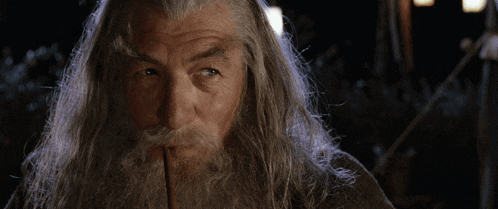 a man with long hair and a beard is looking at something