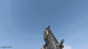 a person is holding an assault rifle with a blue sky in the background ..