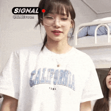 a girl wearing glasses and a white california 1984 t-shirt