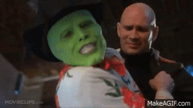 a man in a cowboy hat is holding a woman in a green mask