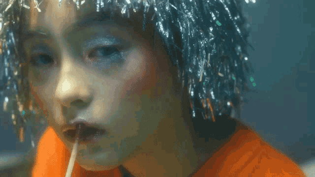 a close up of a woman 's face with silver tinsel on her head
