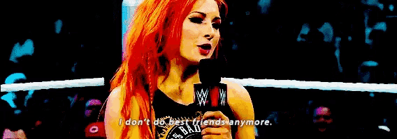 a woman with red hair is holding a microphone in a wrestling ring and says i don t do best friends anymore