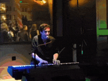 a man playing a keyboard in front of a microphone
