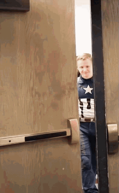 a man in a captain america costume is peeking out of a door