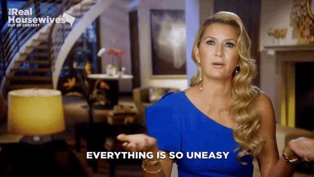 a woman in a blue dress says everything is so uneasy in front of a living room