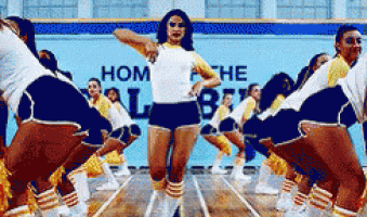 a group of cheerleaders are performing in front of a sign that says home of the best