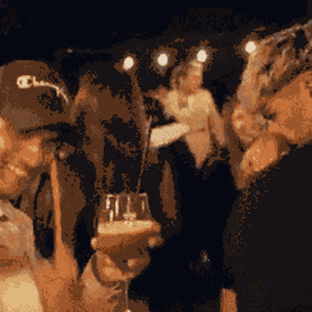 a man wearing a champion hat is holding a glass