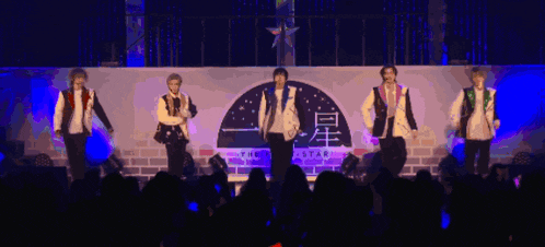 a group of people on stage with a sign that says the star in the background
