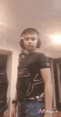 a young man wearing headphones and a black shirt with the letter b on the sleeve