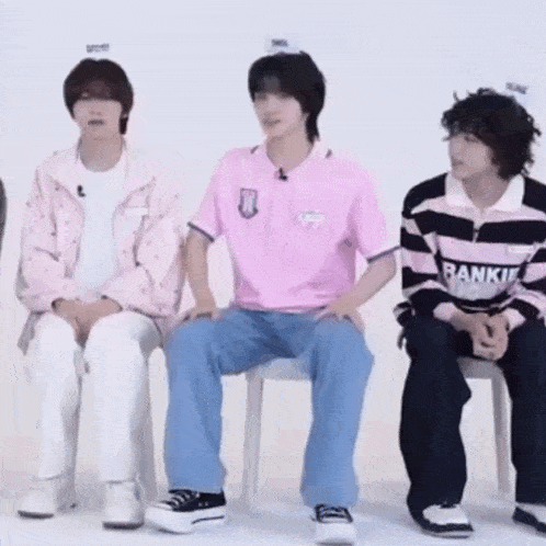 a group of young men are sitting in chairs .