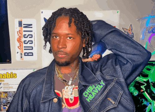 a man in a denim jacket with the word bussin on the front
