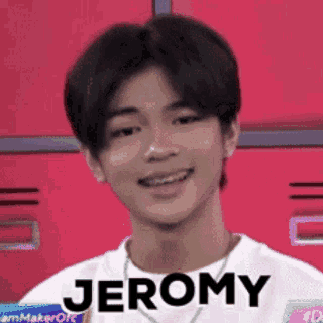 a young man with braces on his teeth is smiling and wearing a white shirt with the name jeromy on it .