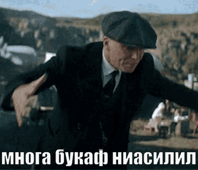 a man in a suit and hat is dancing in front of a sign that says manya