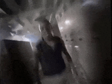 a man is walking down a dark hallway .