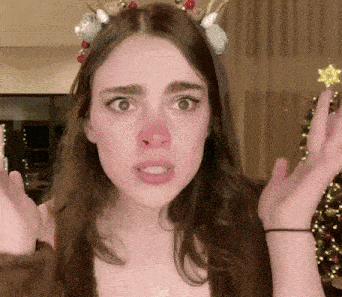 a woman wearing a reindeer headband and a red nose