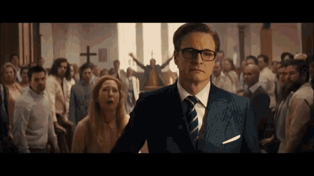 a man in a suit and tie is standing in front of a crowd