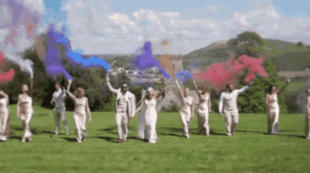 a group of people holding colored smoke grenades in a field