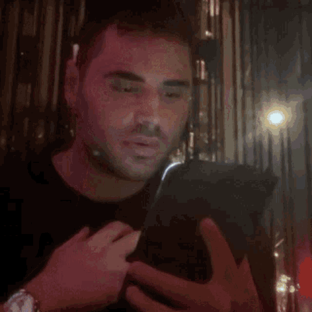 a man wearing a watch is covering his face with his hands