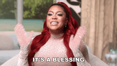 a woman with red hair says it 's a blessing with her arms in the air