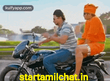two men are riding a motorcycle and one of them is wearing an orange turban