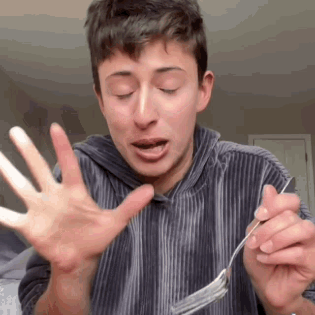 a woman in a striped shirt is holding a fork