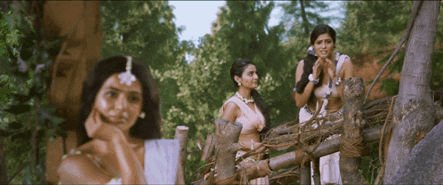 a group of women standing next to each other on a fence